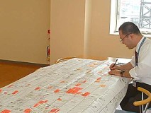 膨大な事務作業の流れを表にして点検中。こうして無駄な作業をあぶりだす